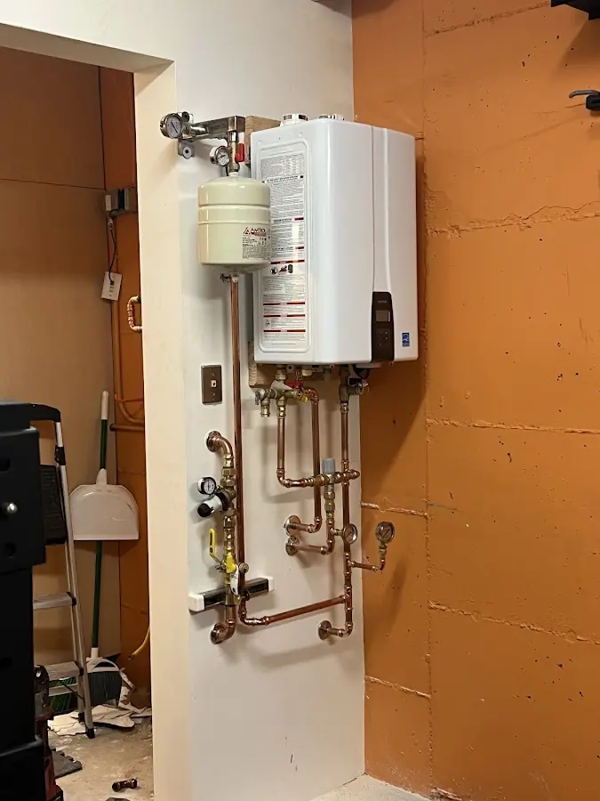 Plumbing technician inspecting water heater connections in Carmichael